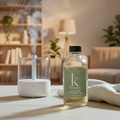Bottle of diffuser fragrance oil with a green label on a neutral background