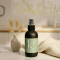Matte black room and linen spray bottle for home fragrance, styled on a tabletop with dried florals